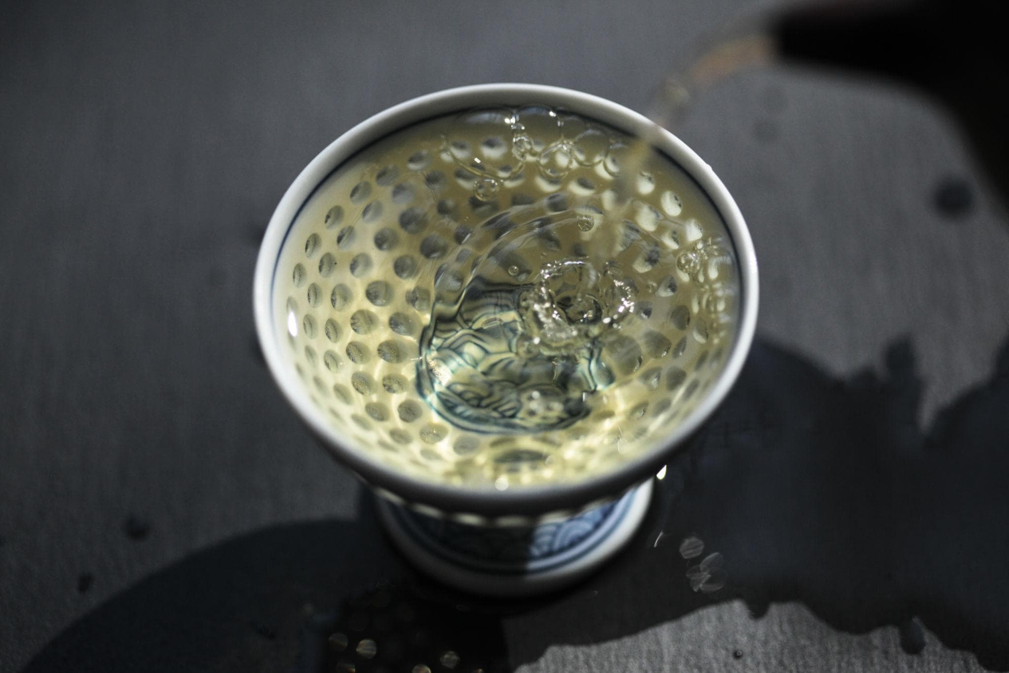 Tea pouring into porcelain cup